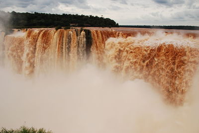 Scenic view of waterfall against sky