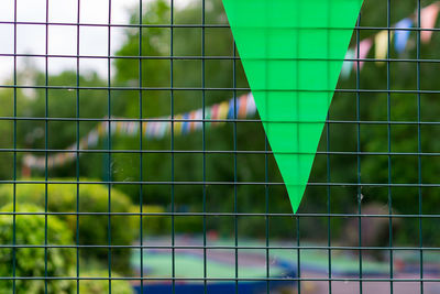 Close-up of bunting seen through fence