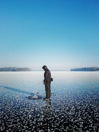Full length of man fishing in frozen lake