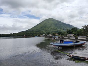 Scenic view of river by mountains against sky