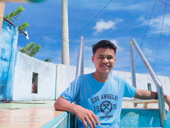 Portrait of young man standing against sky