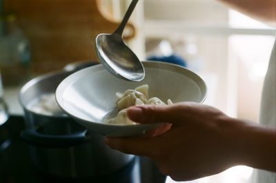 Cropped hands of woman serving food in bowl