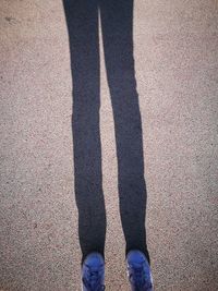 Low section of man standing on shadow