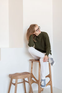 Young woman sitting on chair at home