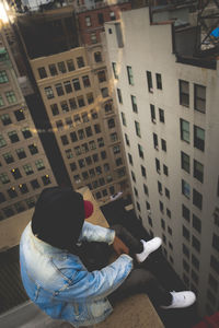 Rear view of woman sitting on office building