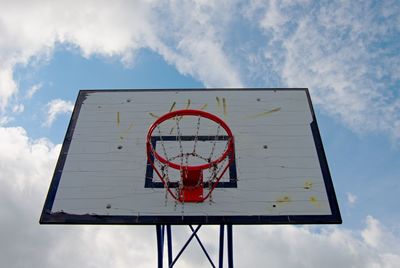 Old worn out basketball hoop and blue sky in background. street basketball court
