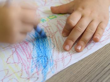 Close-up of boy drawing paper on table