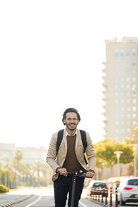 Content man with using e-scooter in the city