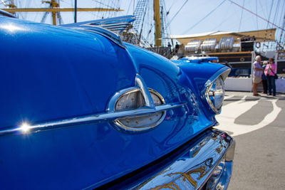 Close-up of blue car on city street