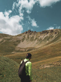 Rear view of man on arid landscape against sky