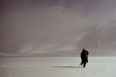 Full length of woman walking on snow covered land