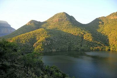 Scenic view of lake by mountains against sky