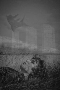 Portrait of woman sitting on field against sky