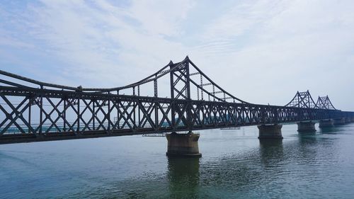 View of bridge over river against cloudy sky