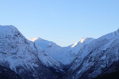 Scenic view of snowcapped mountains against clear blue sky