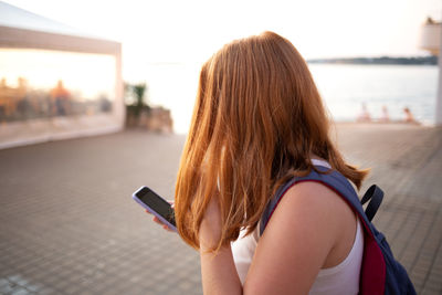 Rear view of woman using mobile phone