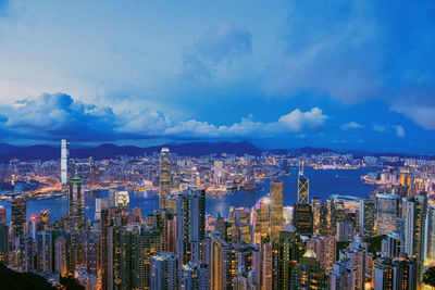 Aerial view of city buildings against cloudy sky