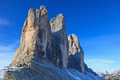 Low angle view of rock formation against clear blue sky