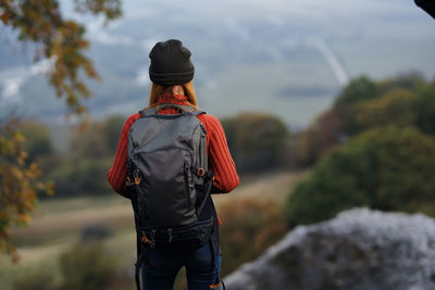 Rear view of woman standing against trees