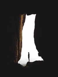 Silhouette man standing in cave