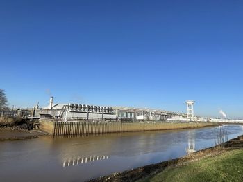 Bridge over river against clear blue sky