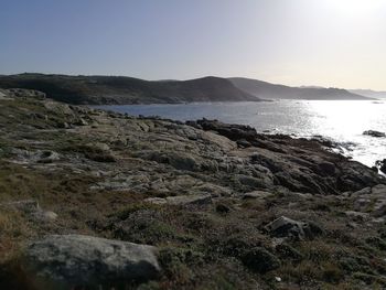 Scenic view of sea and mountains against clear sky