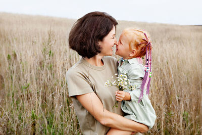 Happy mother and daughter hugging in nature. family is smiling. natural color, lifestyles