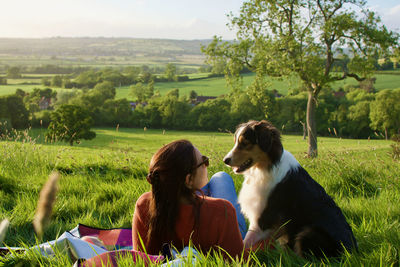 Rear view of woman with dog on field