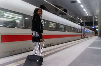 Portrait of woman standing at railroad station