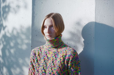 Portrait of woman standing against wall