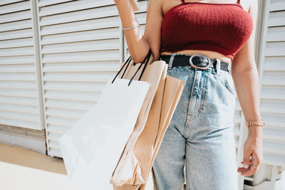 Midsection of woman standing against wall