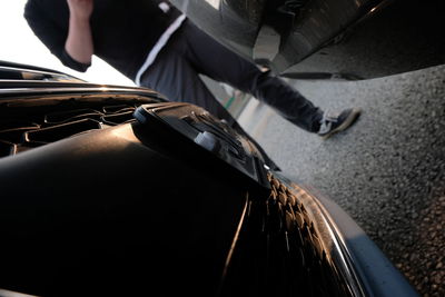 Low section of man on car moving
