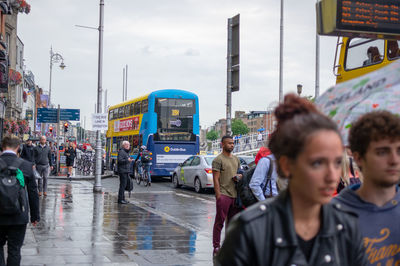 People on wet street in city during rainy season