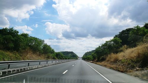 Road amidst trees against sky