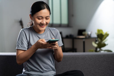 Young man using mobile phone at home