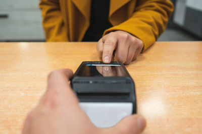 Close-up of  female hand clicking the button to pay at the pos terminal or on a lataphone in a store