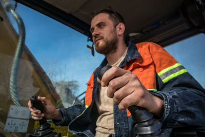 Low angle view of man working in excavator 