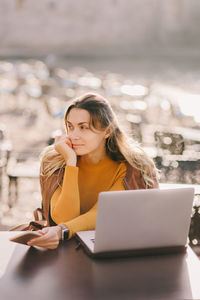 Young woman using laptop at table