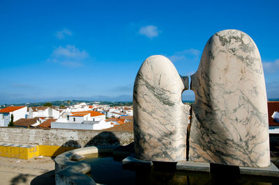 Close-up of sculpture against buildings