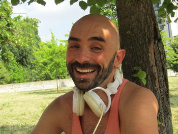 Portrait of smiling young man against trees