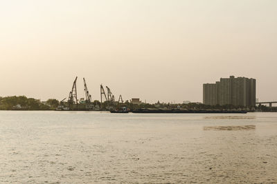 Scenic view of sea and buildings against clear sky