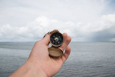 Cropped image of hand holding compass