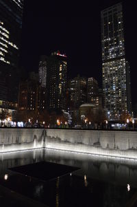 Illuminated buildings by swimming pool at night