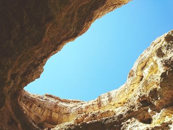 Low angle view of rock formation against clear blue sky