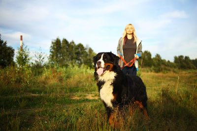 Woman standing with dog outdoors