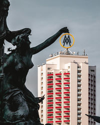 Low angle view of statue against building in city