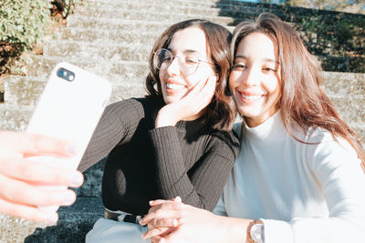 Smiling friends taking selfie