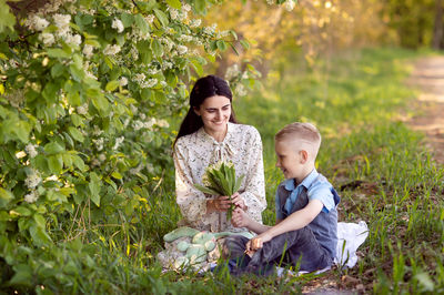 Cute boy with mom on a picnic. son hugs mom