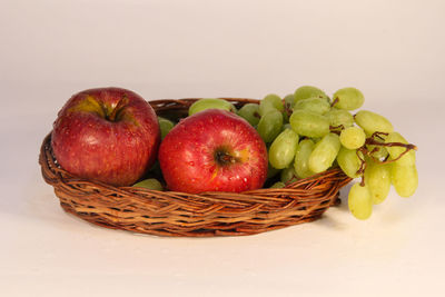 Close-up of apples in basket against white background