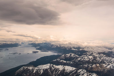Aerial view of sea and mountains against dramatic sky
